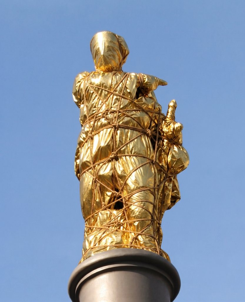 Estatua de Galceran Marquet, de Damià Campeny, envuelta en manta térmica dorada, cuerda y nudos marineros.